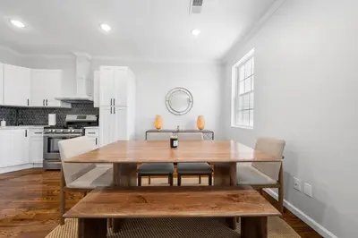a dining room with a wooden table in a kitchen at Big City Living: Elegant Apartment with NYC Vibes in Jersey City