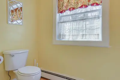 a bathroom with a toilet and a window at 6 Mi to Mt Snow Nature-View Home with Fire Pit! in West Dover