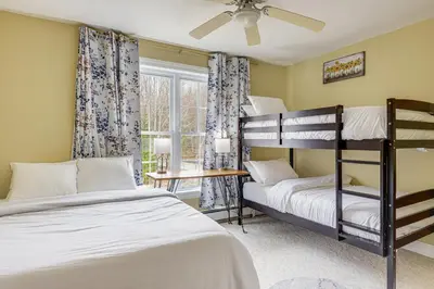 two bunk beds in a room with a window at 6 Mi to Mt Snow Nature-View Home with Fire Pit! in West Dover