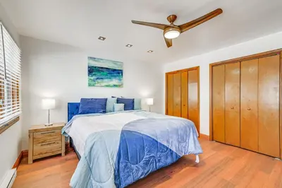 a bedroom with a blue bed and a ceiling fan at Spacious Retreat 7 Mi to Tobyhanna State Park! in Tobyhanna