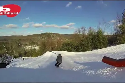 a person riding a snowboard down a snow covered slope at Berkshires Studio Apartment at the Stephentown Hotel in Hancock