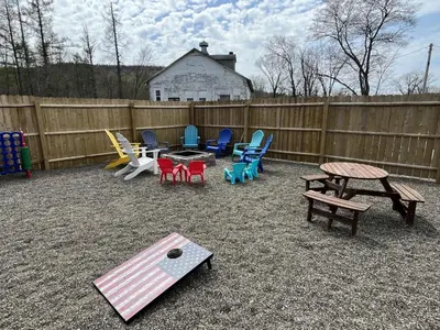 a backyard with chairs and tables and a fence at Berkshires Studio Apartment at the Stephentown Hotel in Hancock