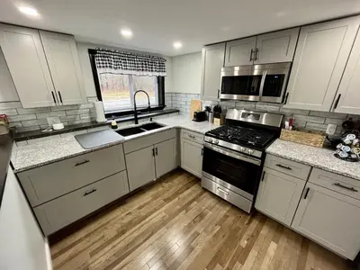 a kitchen with white cabinets and stainless steel appliances at The entire Stephentown Hotel. 28 person occupancy in Hancock