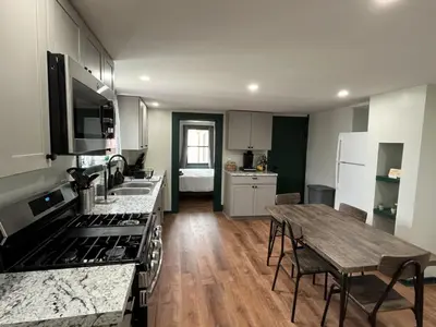 a kitchen with a wooden table and a wooden floor at 2 Bed Berkshire Getaway minutes to Jiminy Peak Ski in Hancock