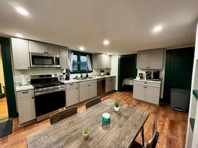 a kitchen with a wooden table and a wooden floor at 2 Bed Berkshire Getaway minutes to Jiminy Peak Ski in Hancock