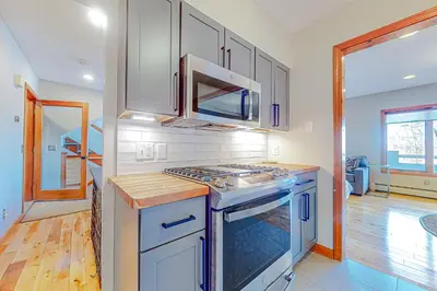 a kitchen with white cabinets and a stove top oven at Alpine Abode in Dover