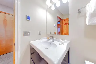 a white bathroom with a sink and a mirror at Alpine Abode in Dover