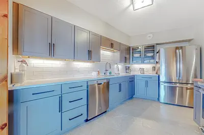 a kitchen with blue cabinets and stainless steel appliances at Alpine Abode in Dover