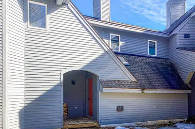 a white house with a red door at Alpine Abode in Dover