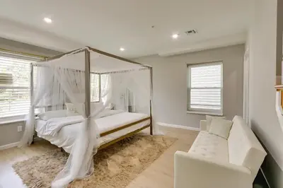 a bedroom with a white canopy bed and a couch at Modern City Getaway Near Downtown Newark & NYC in Newark