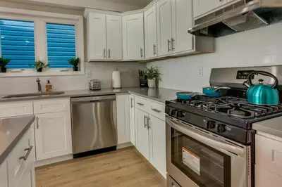 a kitchen with white cabinets and a stove top oven at Modern City Getaway Near Downtown Newark & NYC in Newark