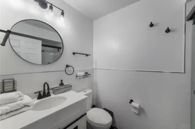 a white bathroom with a sink and a mirror at Huge 3BR Urban Gem just 3 miles to NYC plus Free Parking in Jersey City