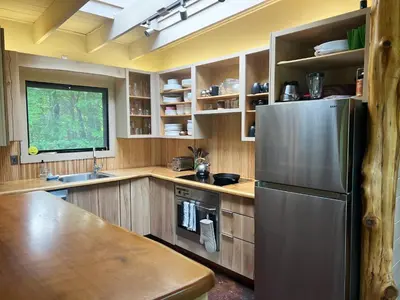 a kitchen with a stainless steel refrigerator and wooden cabinets at Casa Del Rio in Margaretville