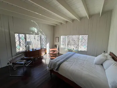 a bedroom with a large bed and two windows at Casa Del Rio in Margaretville