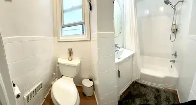 a white bathroom with a toilet and a sink at 9-A Diamond in Yonkers, NY in Yonkers