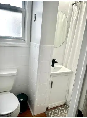 a bathroom with a toilet and a sink and a mirror at 9-A Diamond in Yonkers, NY in Yonkers
