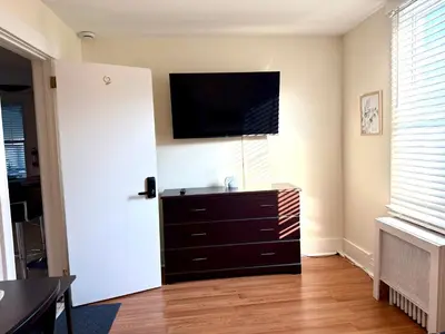 a living room with a dresser with a television on the wall at 9-A Diamond in Yonkers, NY in Yonkers