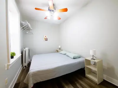 a bedroom with a bed and a ceiling fan at Charming 1BR Apartment Near NYC Ideal for Urban Explorers in Jersey City