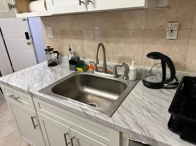 a kitchen counter with a stainless steel sink at Cozy 3 BR suite, 15 min to NYC &Times Sq in North Bergen