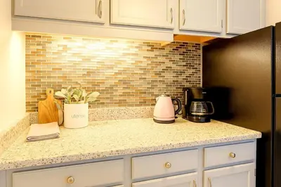 a kitchen with white cabinets and a black refrigerator at Downtown Hartford Condo - Ciy Center - Prime Location in Hartford