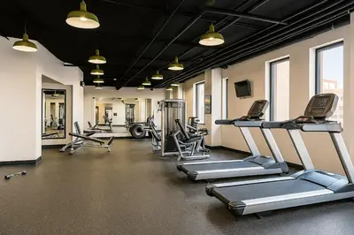 a gym with several treadmills and machines in it at Downtown Hartford Condo - Ciy Center - Prime Location in Hartford
