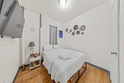 a white bedroom with a bed and a window at Tranquil Haven 1-Bdr Apt in Downtown Manhattan's Union Square in New York
