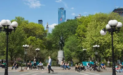 a group of people sitting on benches in a park at Tranquil Haven 1-Bdr Apt in Downtown Manhattan's Union Square in New York