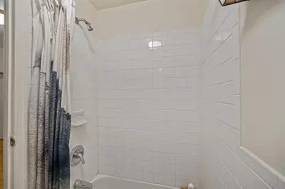 a bathroom with a shower with white tile at Tranquil Haven 1-Bdr Apt in Downtown Manhattan's Union Square in New York