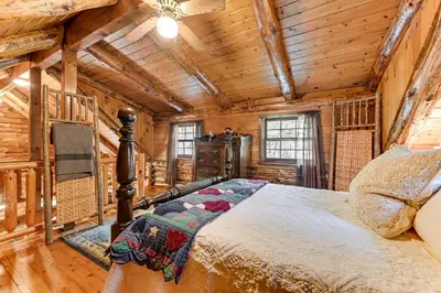 a bedroom with a bed in a log cabin at Lake and Beach Access at Lake Luzerne Cabin! in Lake Luzerne