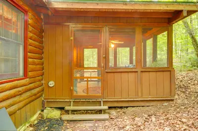 a wooden cabin with a door and a window at Lake and Beach Access at Lake Luzerne Cabin! in Lake Luzerne