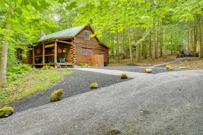 a cabin in the woods with a gravel road at Lake and Beach Access at Lake Luzerne Cabin! in Lake Luzerne