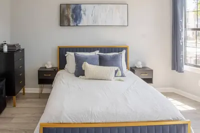 a bedroom with a large bed with blue pillows at Black Rock Suites-86-1 in Bridgeport