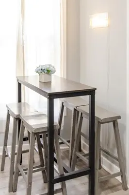 a wooden table with a bench and a table and chairs at Black Rock Suites-86-1 in Bridgeport