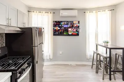 a kitchen with a stainless steel refrigerator and a table at Black Rock Suites-86-1 in Bridgeport