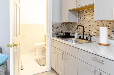 a white kitchen with a sink and a toilet at Black Rock Suites-86-1 in Bridgeport