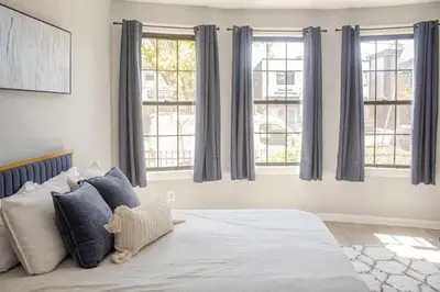 a bedroom with a large bed with blue curtains at Black Rock Suites-86-1 in Bridgeport