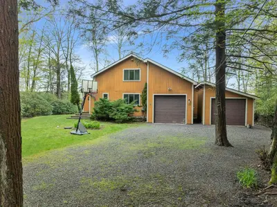 a house with a garage and a driveway at Lakefront Family Home, Kayaks, Hot Tub, Fireplace in Lake Ariel
