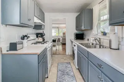 a kitchen with blue cabinets and a sink at Beachside in Branford in Stamford
