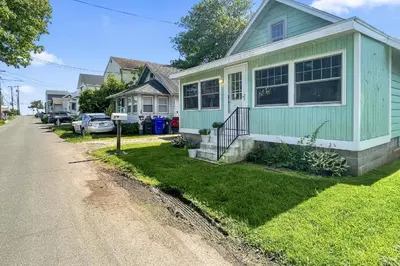 a green house on the side of a street at Beachside in Branford in Stamford