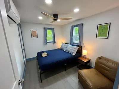 a bedroom with a blue bed and a couch at Bear Run Bungalow in Hawley