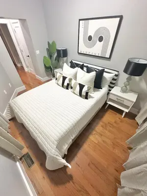 a bedroom with a bed with black and white pillows at Dream Home Close to the Center of NYC in Mott Haven