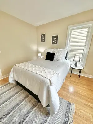 a bedroom with a large white bed and a window at Dream Home Close to the Center of NYC in Mott Haven