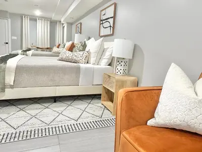 a bedroom with a large bed and a chair at Dream Home Close to the Center of NYC in Mott Haven