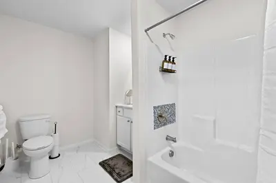 a white bathroom with a toilet and a shower at Home Sweet Home - near NWK & NYC w/free parking in Newark