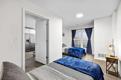 a bedroom with two beds and a mirror at Home Sweet Home - near NWK & NYC w/free parking in Newark