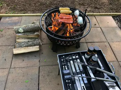 a grill with hot dogs and tongs on it at Red Creek Hideaway in Cooperstown NY in Cooperstown