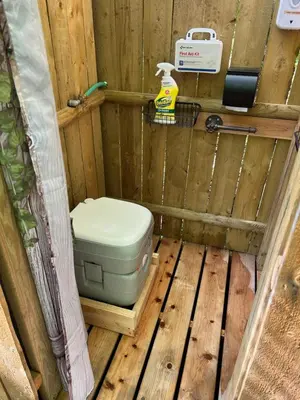 a bathroom with a toilet in a wooden structure at Red Creek Hideaway in Cooperstown NY in Cooperstown