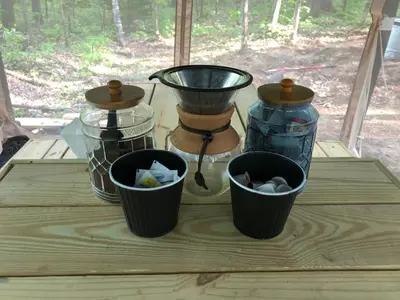three glass jars on a wooden table with buckets at Red Creek Hideaway in Cooperstown NY in Cooperstown