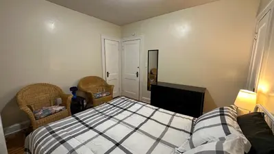 a bedroom with a bed and two chairs and a television at Cozy Albany Home in Albany