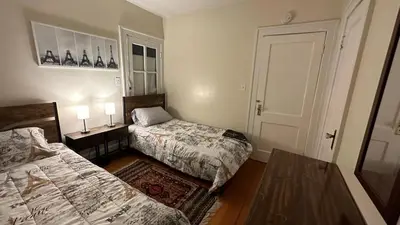 a bedroom with two beds and a door with two lamps at Cozy Albany Home in Albany